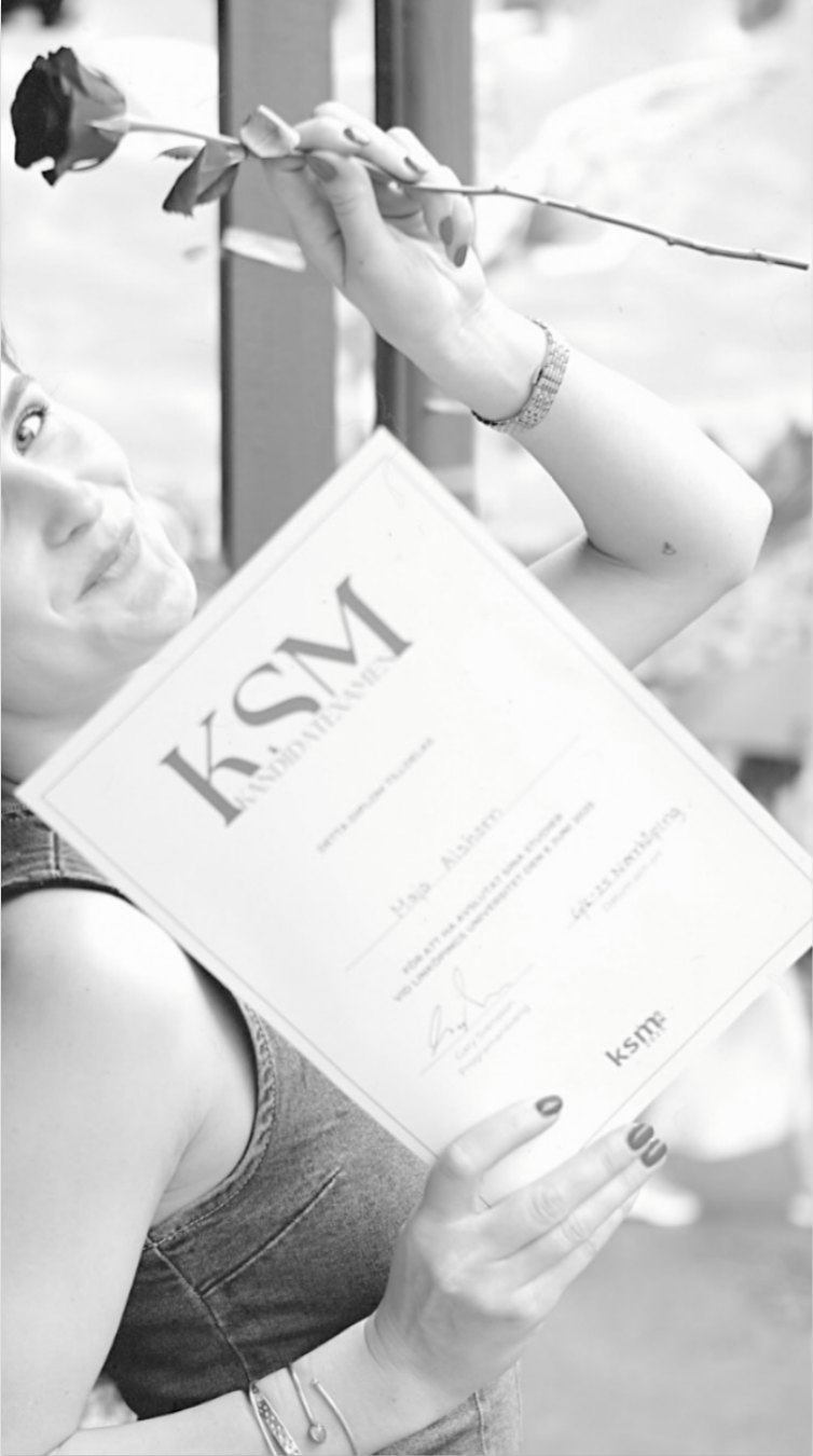 Svartvitt foto av person som håller examensdiplomet